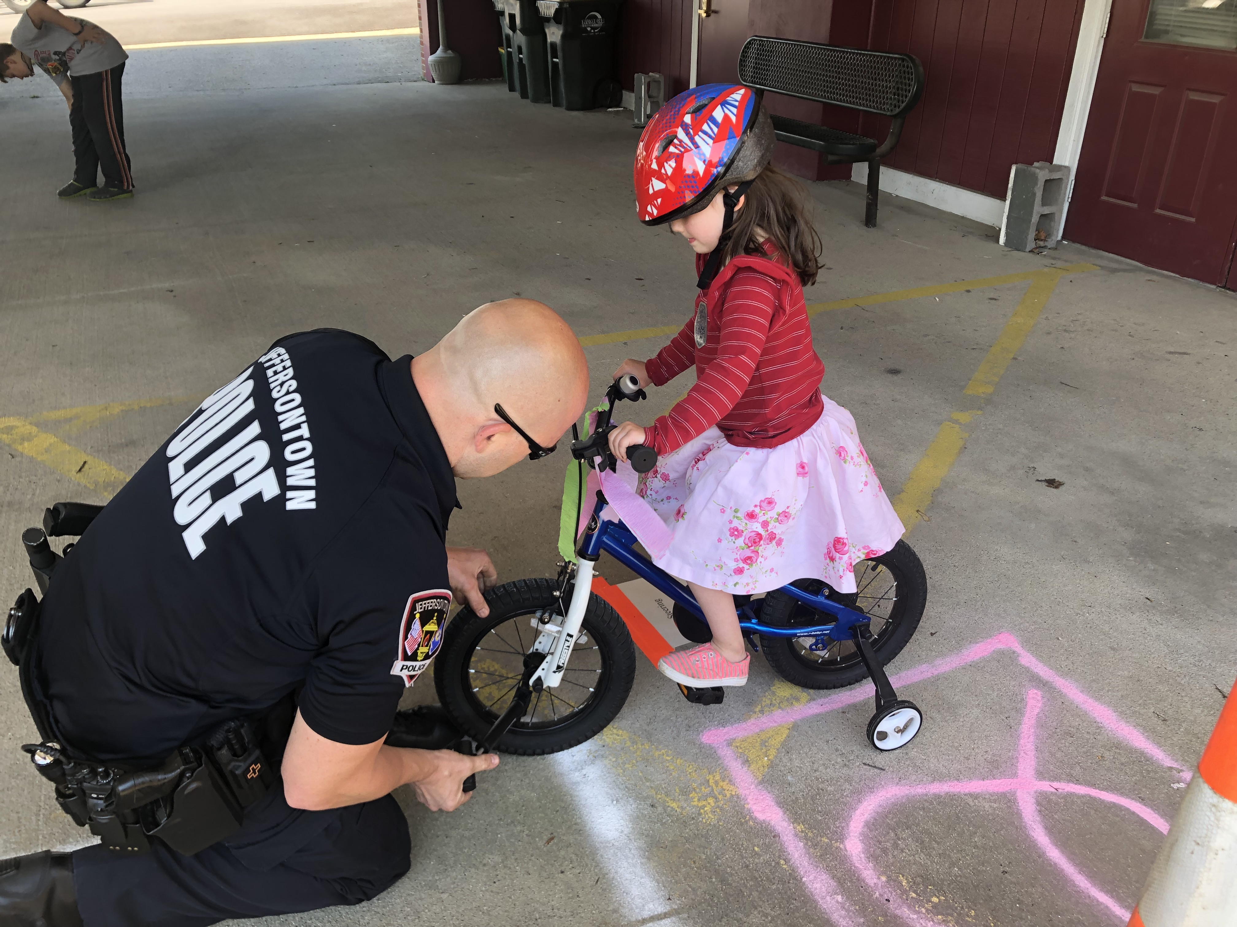 Jeffersontown Police officer helping a child with bicycle safety