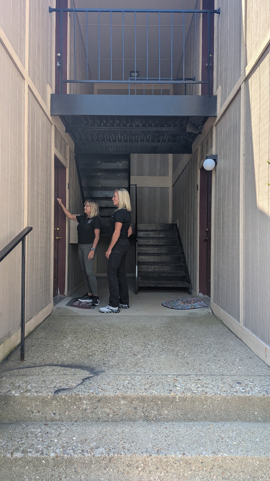Two REACH staff members at a doorway, with one knocking